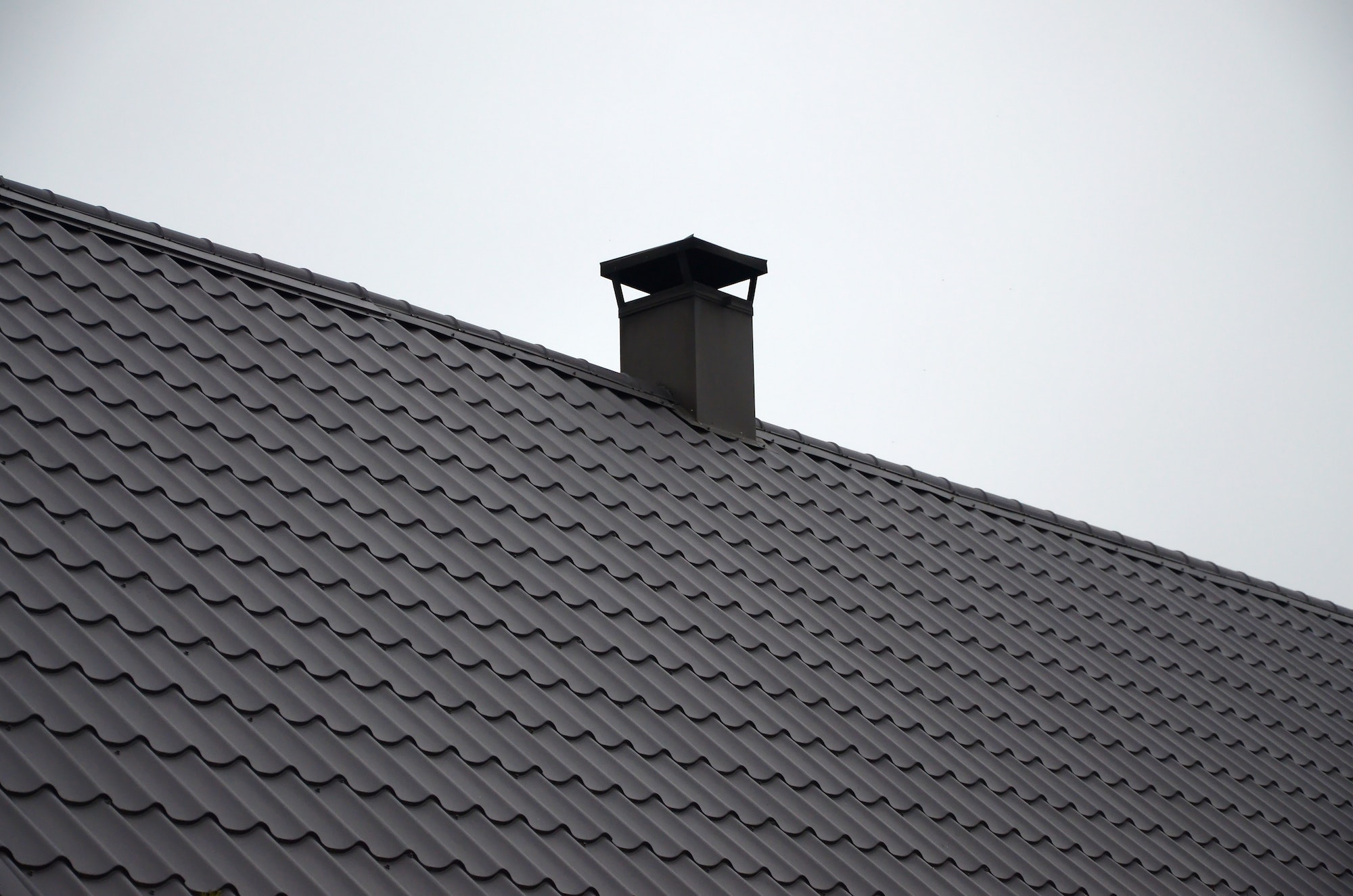 Modern brown roof made of painted metal. Corrugated metal roof and metal roofing industry concept